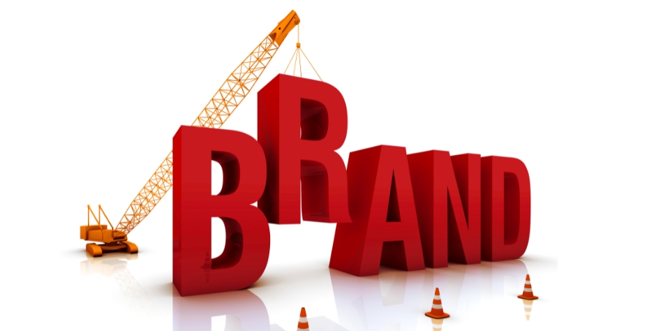 Crane lifting the letter "A" in the word BRAND symbolizing brand building and development.